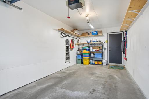 Finished extra-deep garage featuring built-in storage shelves and plenty of room for additional storage