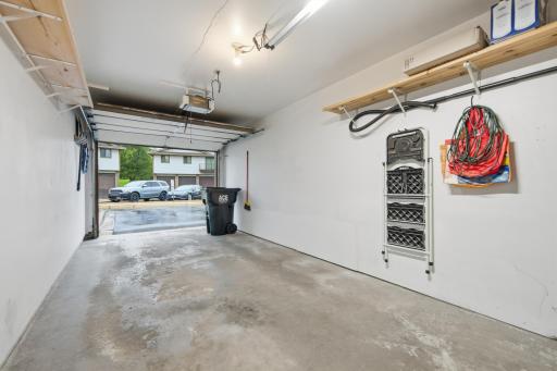 Finished extra-deep garage featuring built-in storage shelves and plenty of room for additional storage