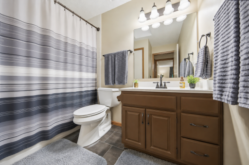 Bright bathroom featuring a skylight, tile flooring, and a convenient storage closet for added functionality.