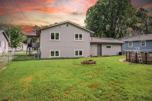 Private backyard retreat complete with fire pit, above-ground pool, screened porch, and generous green space for pets, play, gardening, or entertaining all summer long.