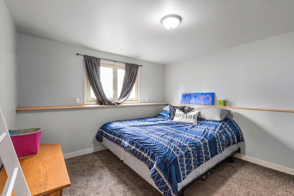 Comfortable lower-level bedroom with egress window, neutral finishes, and generous space for family, guests, or a private retreat.