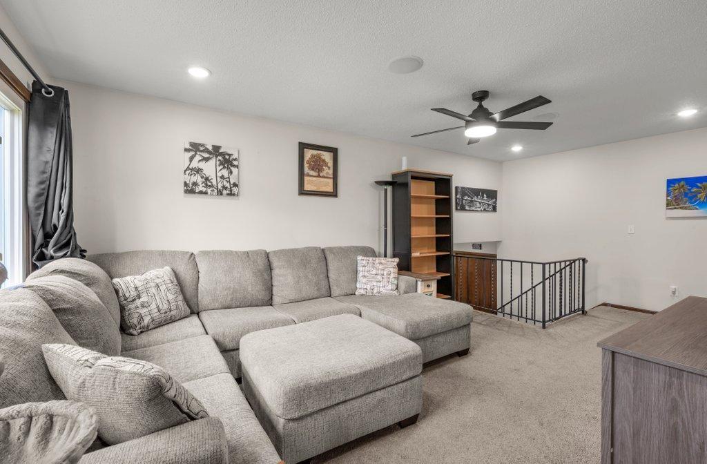 Spacious living room with vaulted ceilings, recessed lighting, plush carpeting, and an open layout that offers plenty of room to relax or entertain guests.
