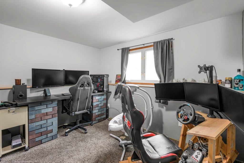 Versatile lower-level bedroom with egress window, ideal as a fourth bedroom, home office, gaming room, fitness space, or hobby room to fit your lifestyle.
