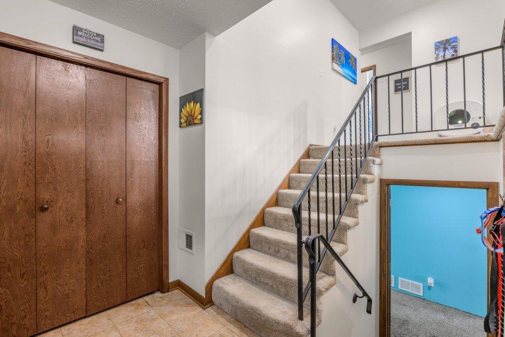 Welcoming split-entry foyer with vaulted ceiling, spacious coat closet, and convenient access to both levels, creating an open and inviting first impression.