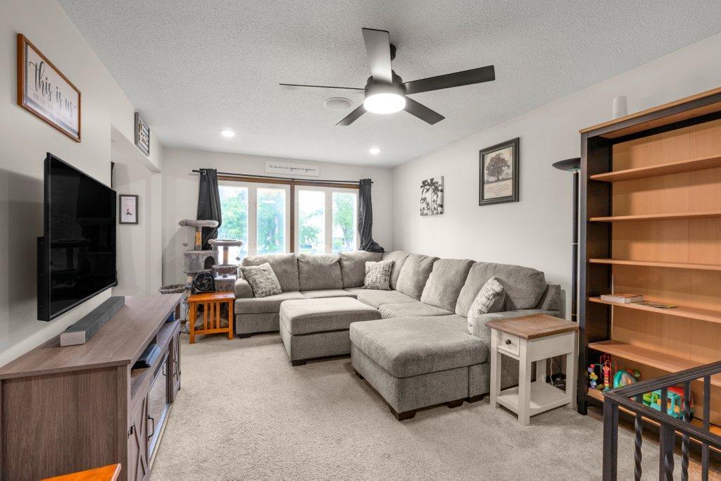 Light-filled family gathering space with oversized windows, vaulted ceiling, modern finishes, and an open floor plan that connects beautifully to the kitchen and dining area.