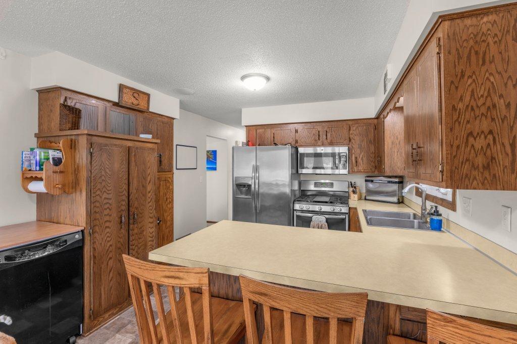The heart of the home! This functional kitchen offers stainless steel appliances, abundant oak cabinetry, ample prep space, breakfast bar seating, and an efficient layout every home chef will appreciate.