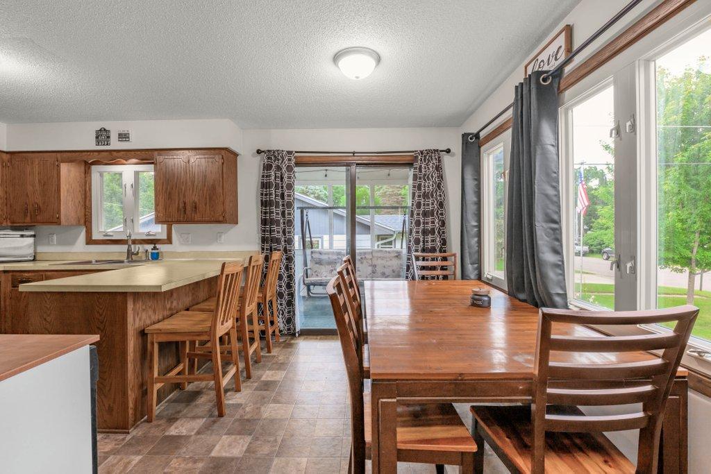 Bright dining area with large windows overlooking the yard, sliding glass door to the deck, and easy access to the kitchen, creating the perfect space for family dinners and summer BBQs.