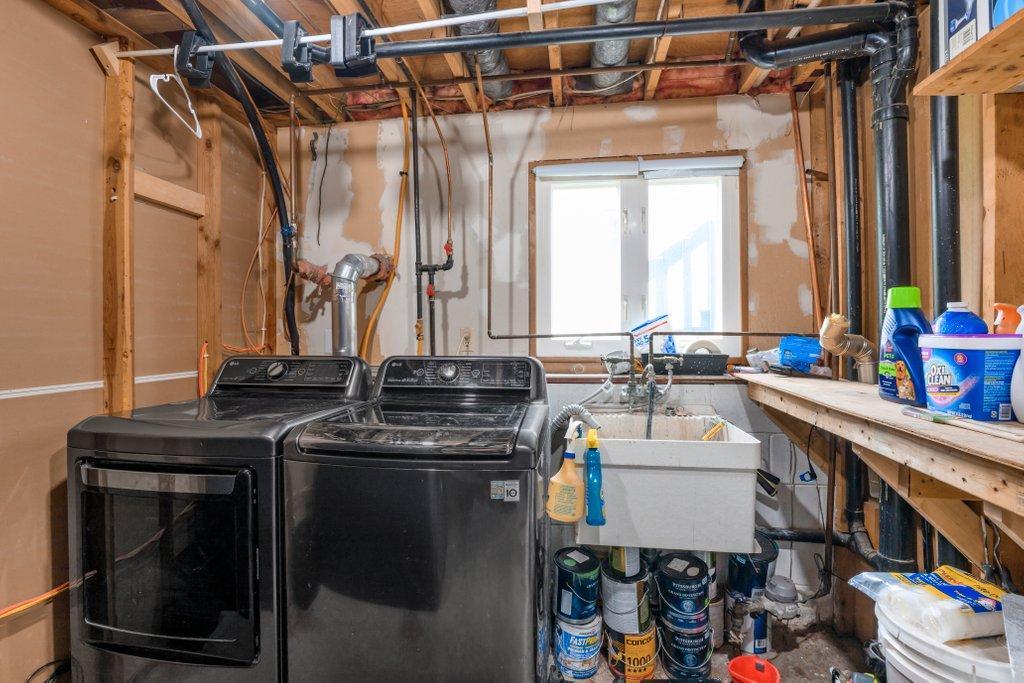 Dedicated laundry and utility room with utility sink, built-in workspace, and additional storage to help keep daily life organized.