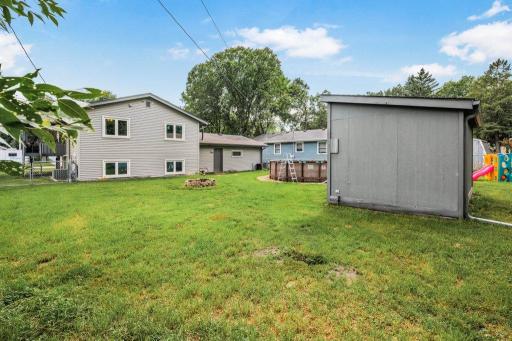 Large backyard offers endless possibilities with mature trees, storage shed, fire pit, and plenty of green space for outdoor fun and entertaining.
