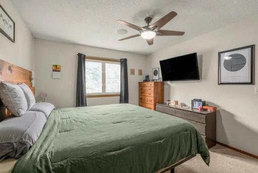 Enjoy a generous primary retreat with large windows, modern ceiling fan, ample wall space for furnishings, and a comfortable layout designed for everyday living.