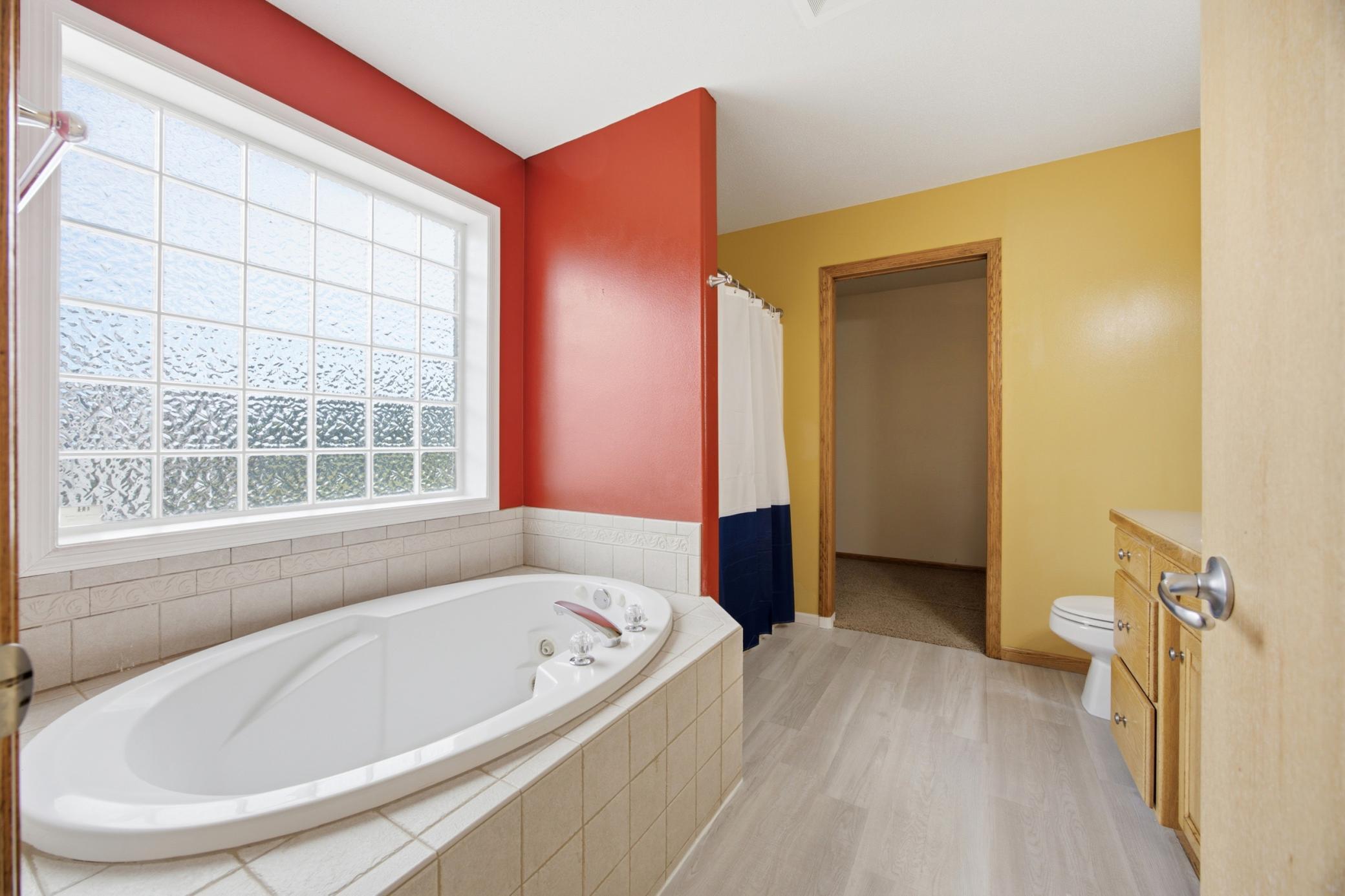 Attached primary bathroom with soaking tub and shower