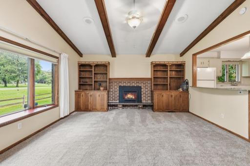 Cozy gas fireplace with built-ins, beamed and vaulted ceiling