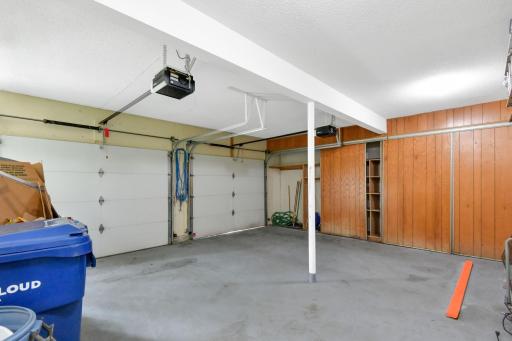 Double garage features sliding doors to hide the tools~ note the built-in shelving behind