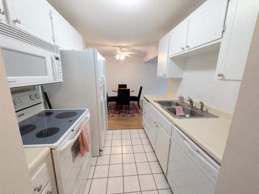 Bright white kitchen with a new faucet and dishwasher