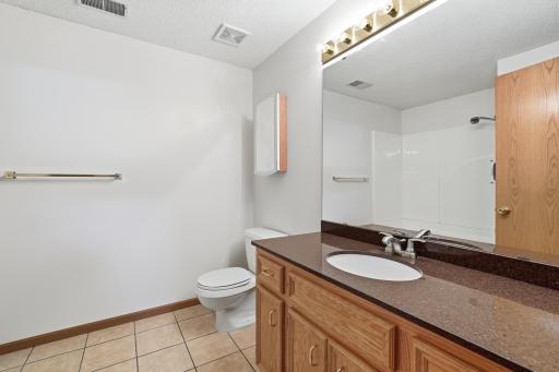 Lower level full bathroom with tile floor and granite countertop