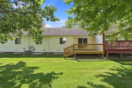 Back view of home and deck overlooking the open lawn area