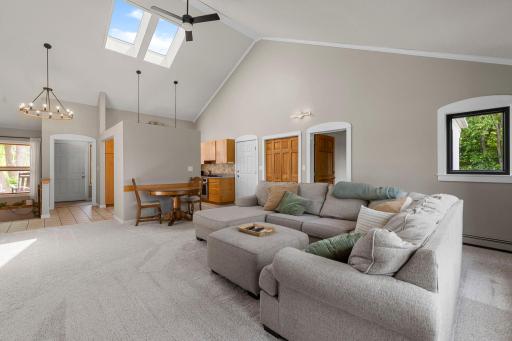The great room has the dining room / living room combination, skylights, ceiling fan and new carpeting.