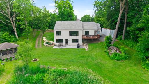 The rear view is complimented with retaining walls, tasteful landscaping, the patio and the deck are all designed to take advantage of the 9+ private acres.