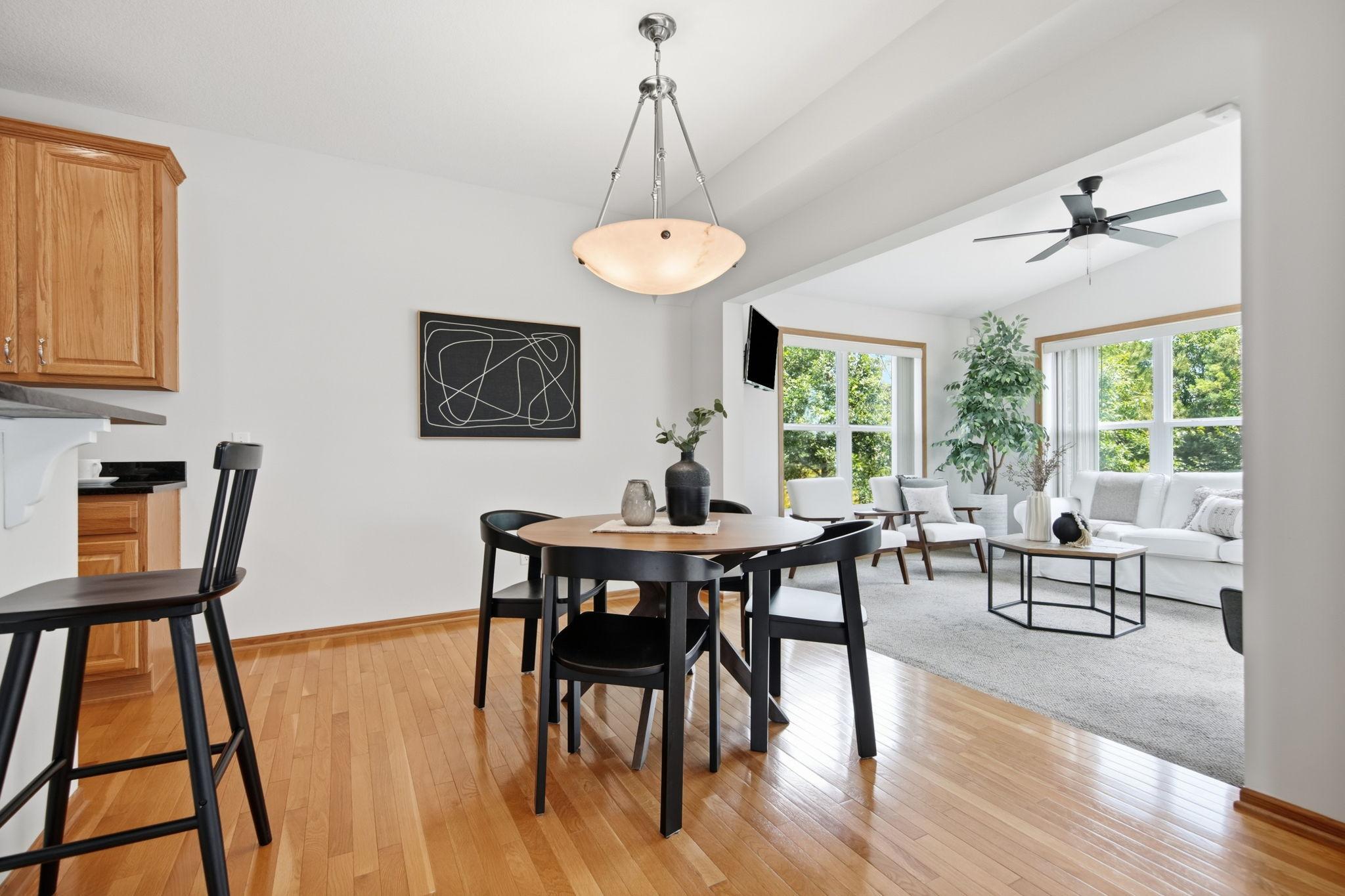 The informal dining room offers a lovely view into the four-season porch and family room, where abundant charm, quality details, and soaring vaulted ceilings create a warm and inviting atmosphere.