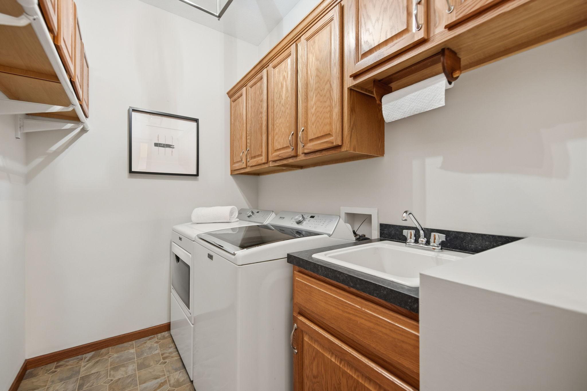 Conveniently located on the main floor, this spacious laundry room offers abundant storage, dedicated hanging space, & a large sink with storage underneath. It also features a brand-new washer and dryer and is one of two laundry rooms in the home.