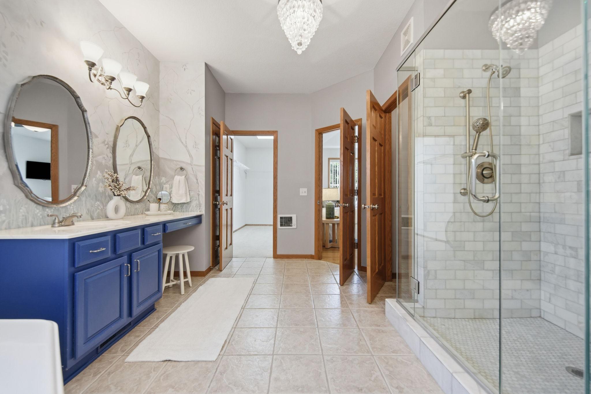 Primary bathroom professionally painted by a local artist - the walls were painted to reflect a nature scene - A serene retreat for soaking in tub, complemented by 2 separate vanity areas offering generous counter & cabinetry space (new shower area.)