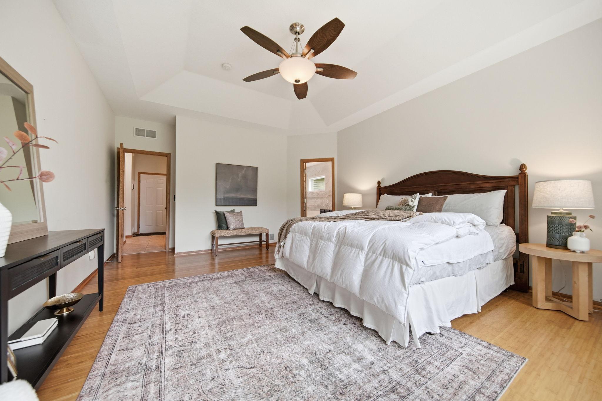 This photo shows the main-floor primary bedroom with an attached primary bath, offering the convenience of aging in place while still leaving plenty of room for grandkids down the road.