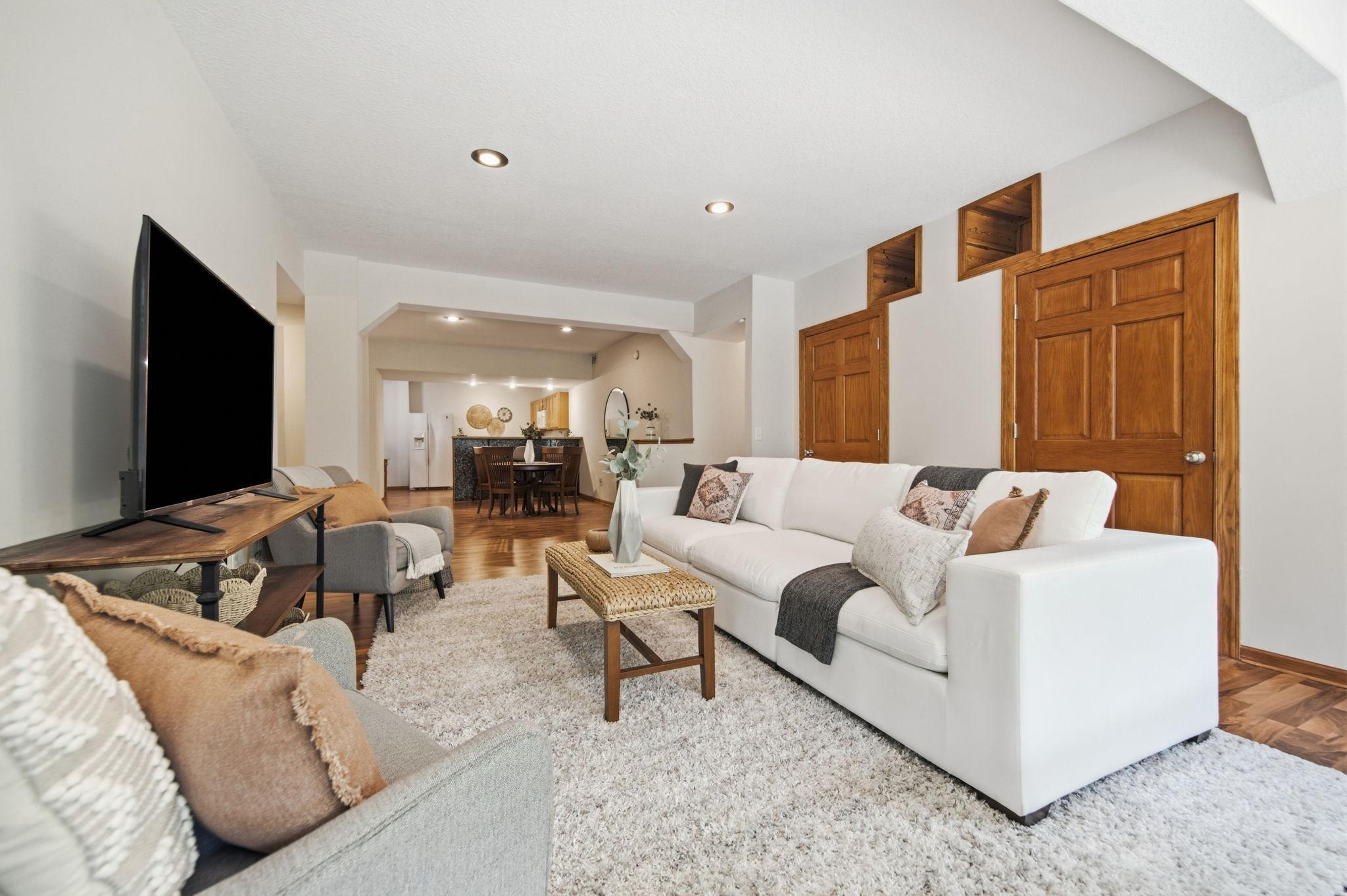 The LL living/family room is thoughtfully designed with upper display cubbies for treasured items and concealed storage behind the two lower doors. walks out to a private patio and is enhanced by oversized daylight windows.