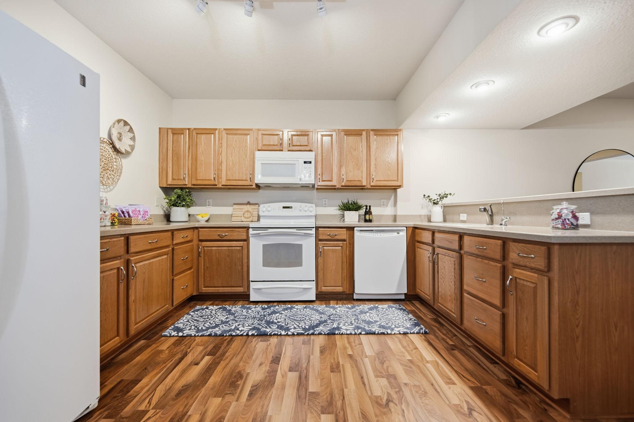 A view of the full Lower Level kitchen equipped with a range/oven, microwave, dishwasher and Refrigerator not to mention lots of counter and cupboard space.