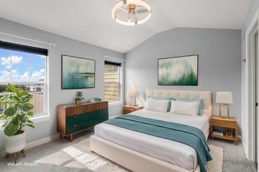 Upper level Primary bedroom, vaulted ceiling with fan/light fixture. Virtually staged.