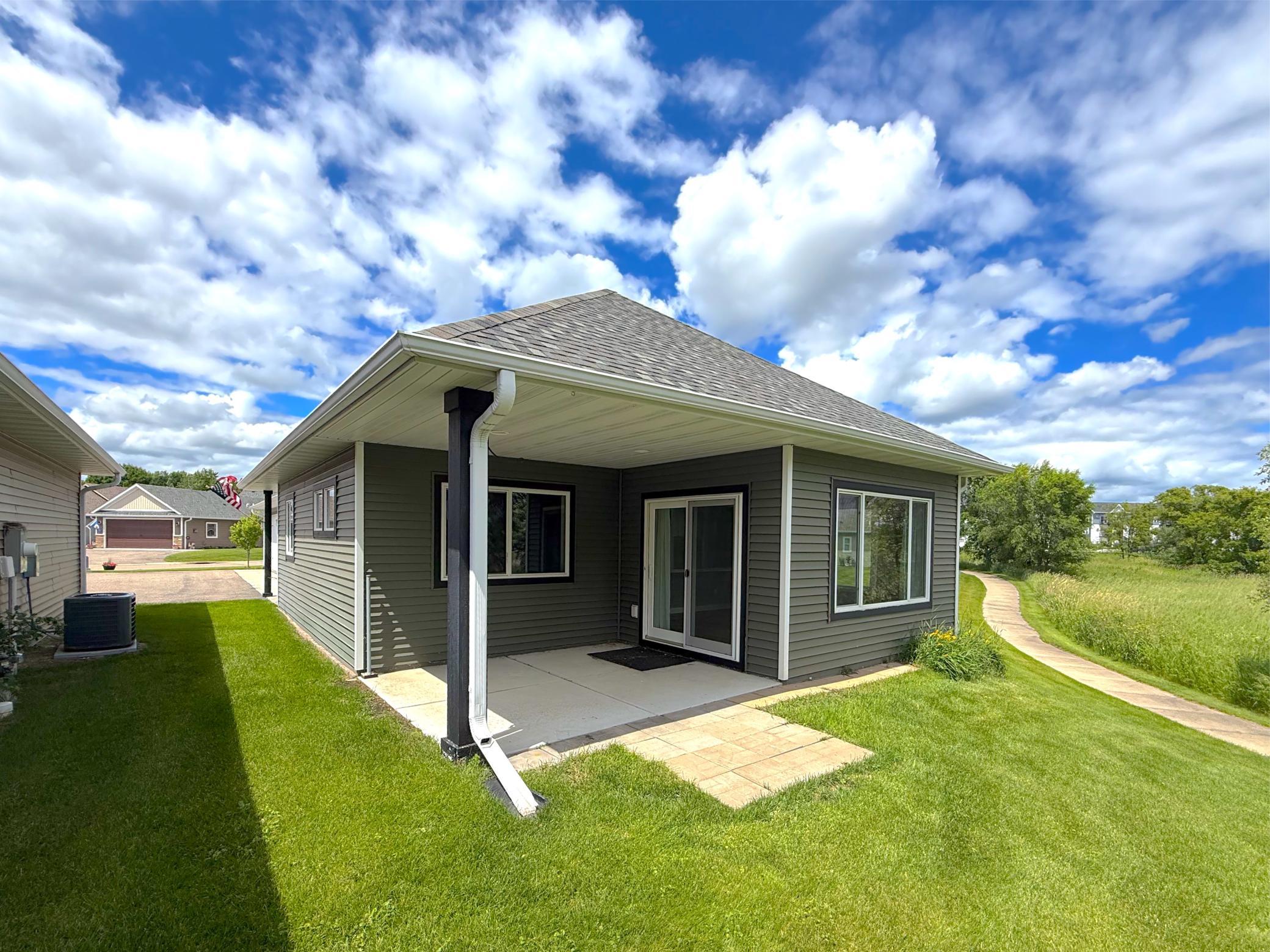Step outside to the covered porch and enjoy the peaceful setting, with the community walking path conveniently located just beyond your backyard