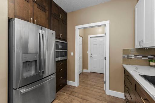 The floor-to-ceiling bank of cabinets feature a french-door fridge and double wall oven