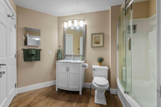 The large soaking tub is highlighted by a curved glass door