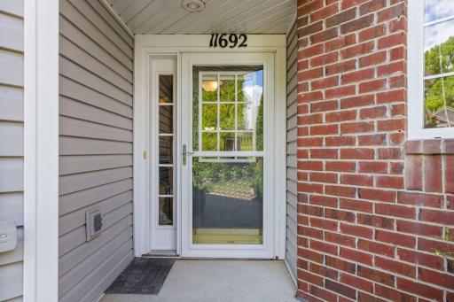 The front entrance features a screen door with retractable screen