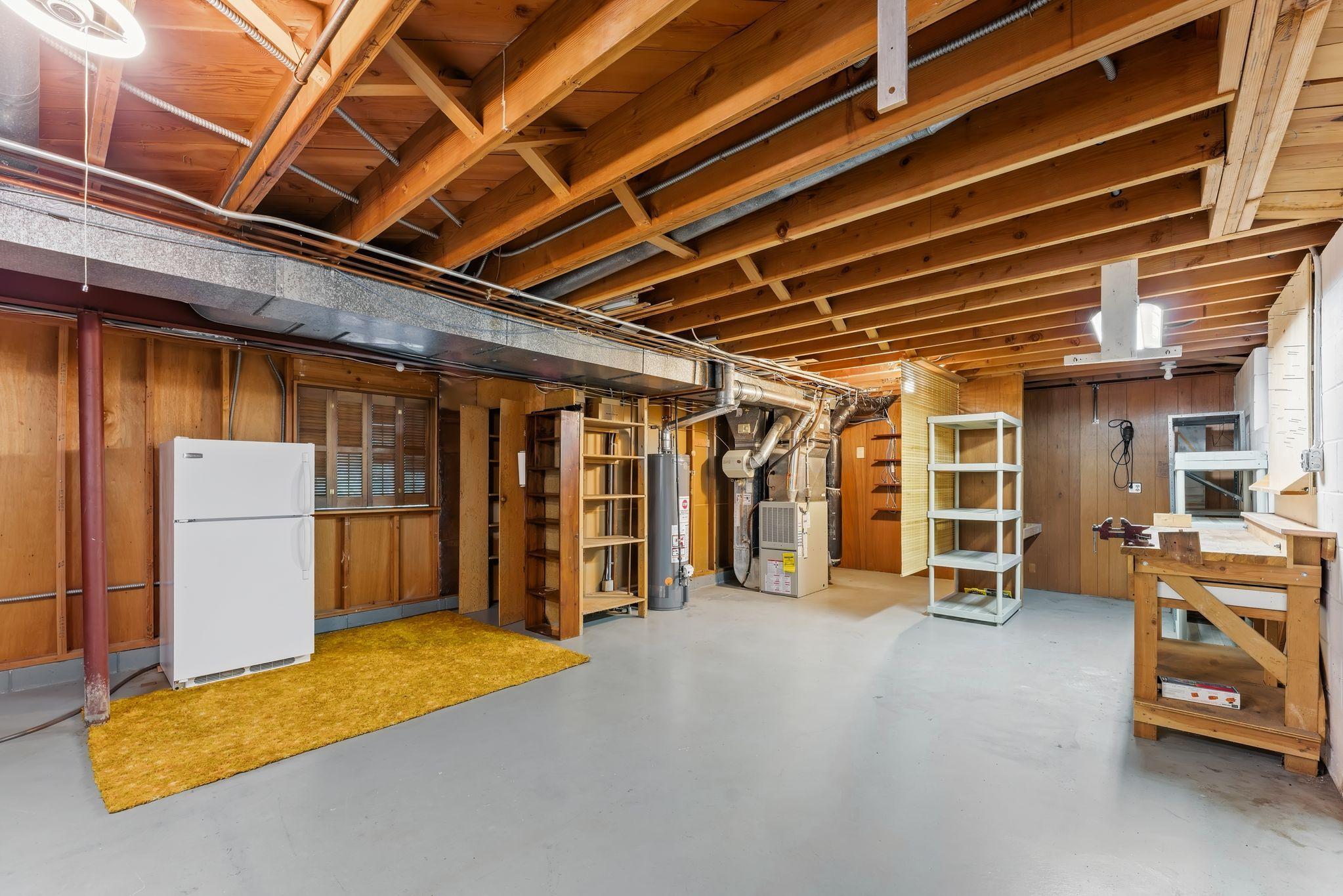 Enormous unfinished space in the lower level of the home, currently used for storage, laundry and a work shop