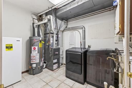 Large laundry, utility space with hook up for laundry sink and lots of storage space, additional space behind the door