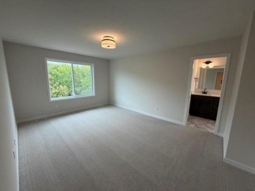 Spacious Primary Suite with separate tub and tiled shower, double sinks, and large walk-in closet