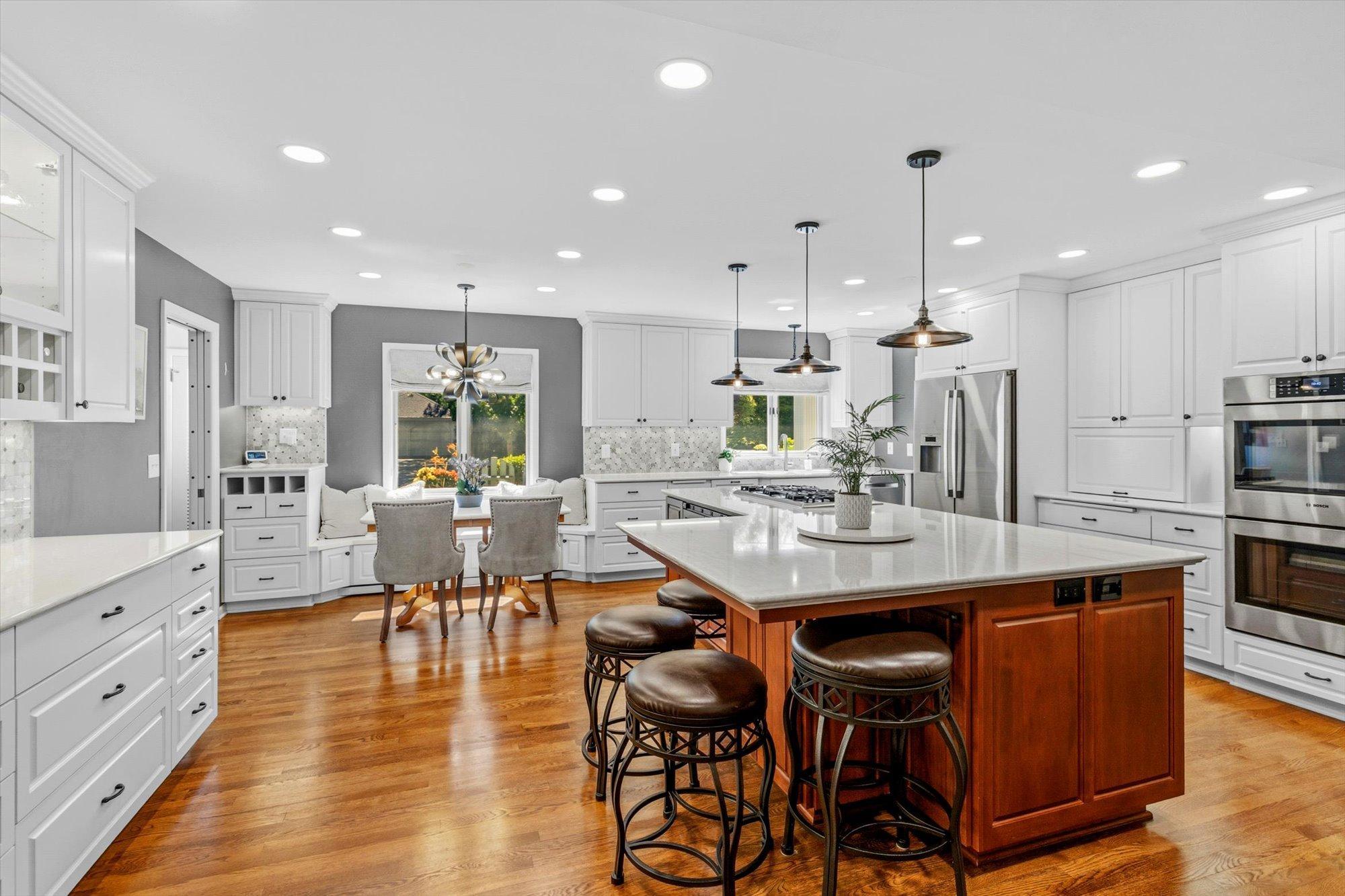Window seat informal dining, breakfast bar, island seating, gas stove top and double wall ovens.