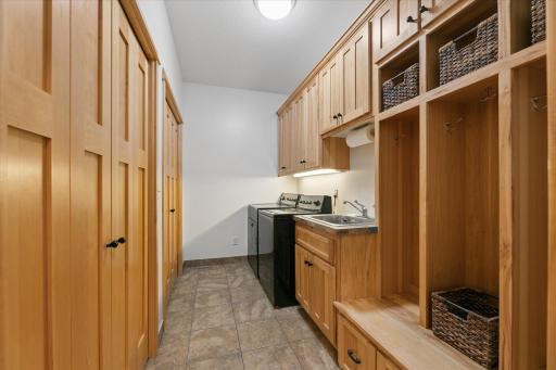 Designated laundry room/mudroom on main level with abundant storage in double closets and overhead cabinets. Convenient locker system for hanging coats and storing shoes & accessories. Tile floors and wash tub make cleanups easy.