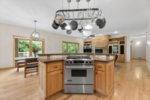 Center island features JENN-AIR gas range with two burners and griddle, down-draft ventilatio, pot filler, overhead chef's pot/pan storage and multiple outlets.