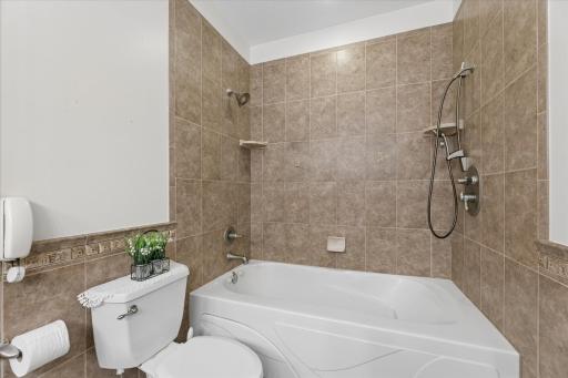 Tiled shower with deep jetted tub, dual showerheads and hand wand.