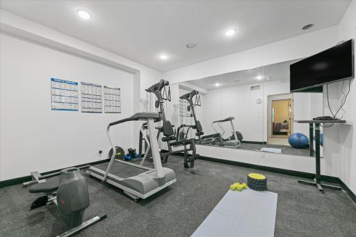 Designated workout room designed with rubber fitness flooring and custom mirrors on 2 full walls. Room for multiple pieces of workout equipment, weight racks and yoga/stretching area.