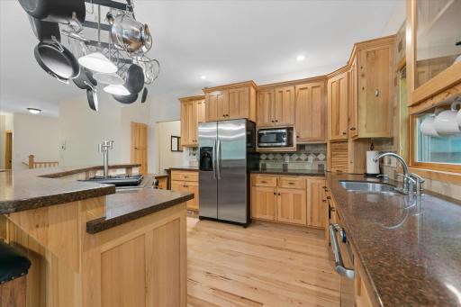 Stainless steel appliances, dark Silestone countertops, upper and under cabinet lighting.
