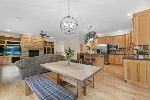 Dining room with space for extended table & seating to host family & friends. Modern chandelier, hickory hardwood floors, open floorplan and large windows to wooded backyard.
