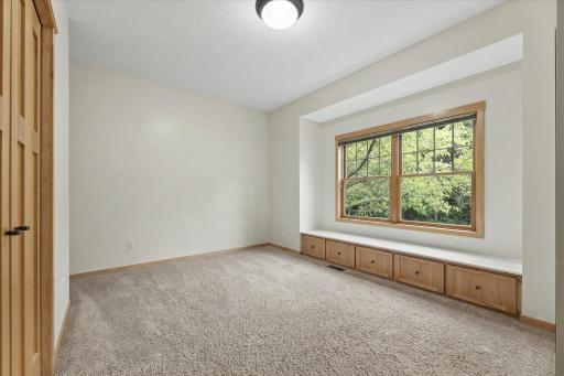 Bedroom #2 on main level. Cantilevered window with seating bench and five storage doors.