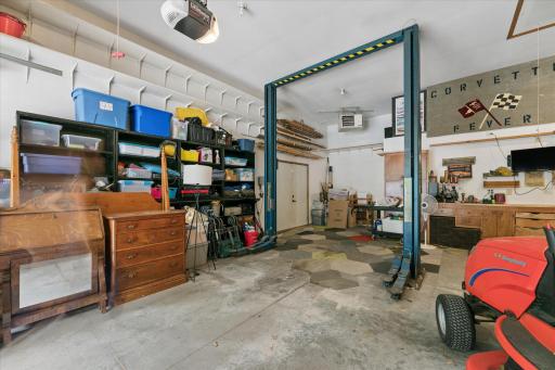 Permanent car lift, dual door opens to side of garage, hanging garage heater, walk-down entry to lower level.