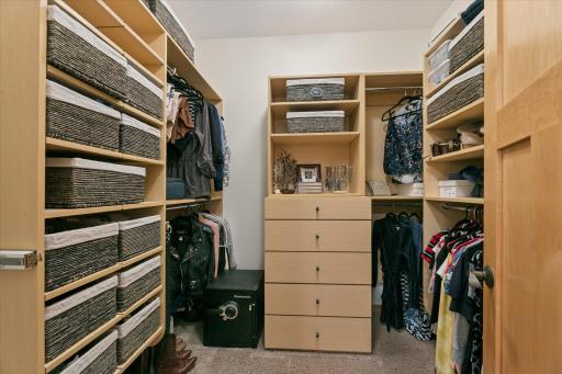 Dreamy walk-in closet for two with a boutique-variety of hang, drawers, and shelves with various organizers & displays.