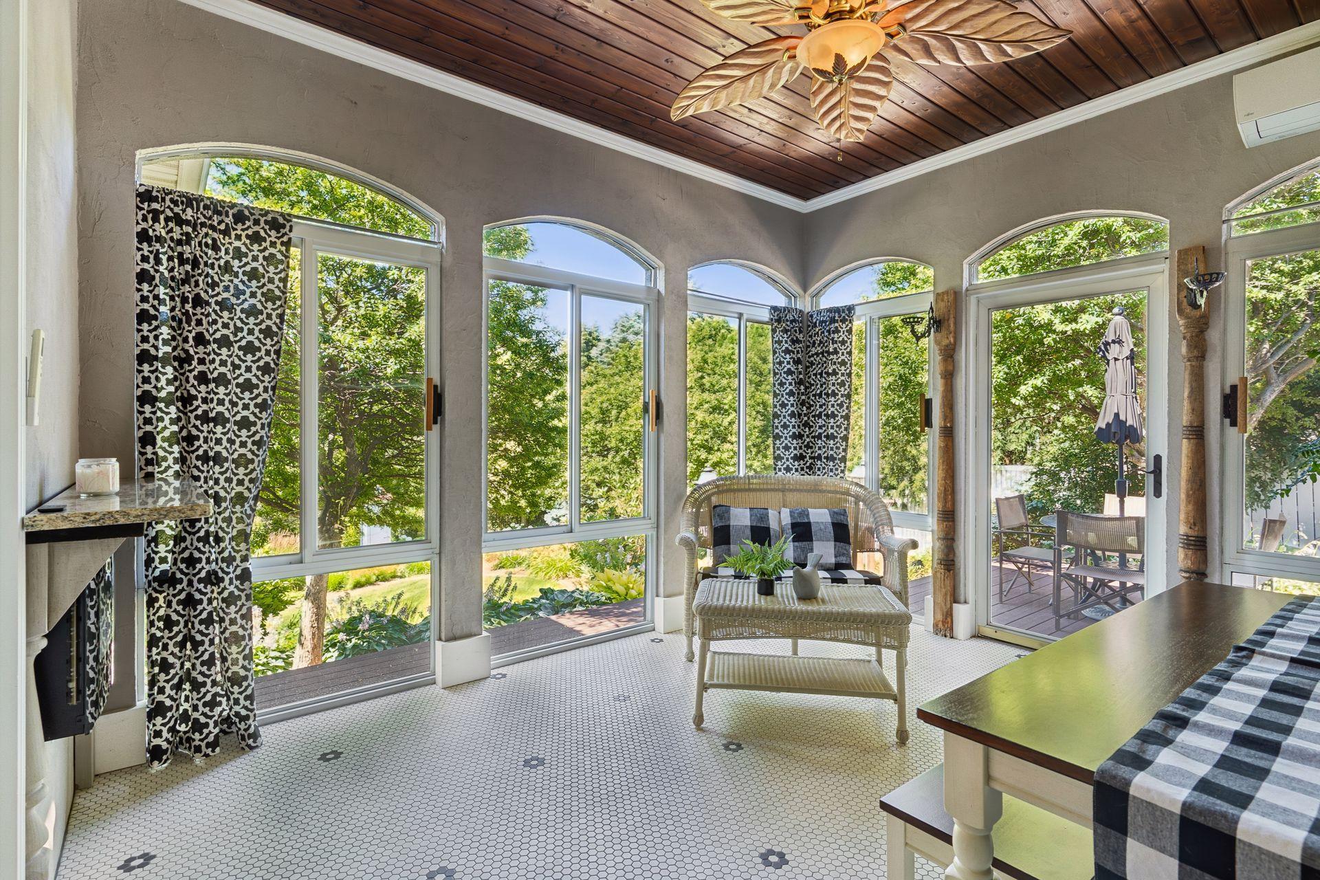 Enjoy the beauty of every season in the heated and cooled Sunroom featuring a rich wood ceiling, electric fireplace, and easy access to the maintenance-free deck.