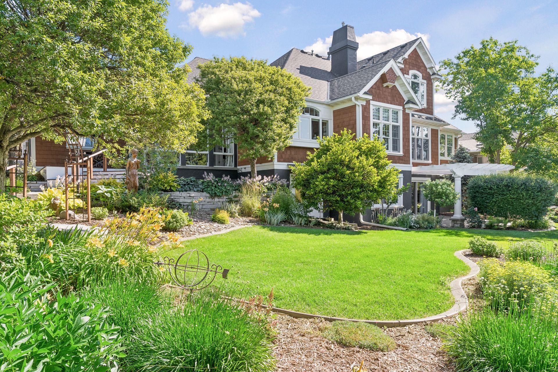 Professionally designed gardens, mature trees, stone retaining walls, and winding pathways create a private backyard that feels like your own botanical retreat.