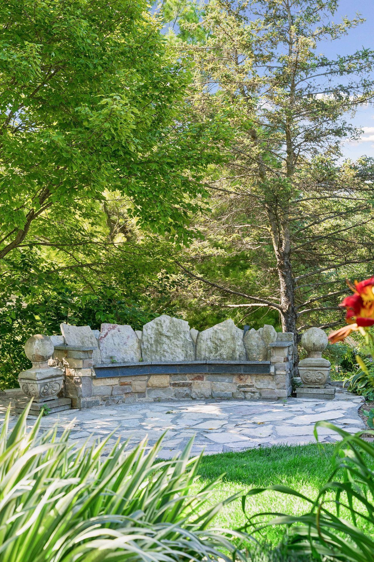 Gather around the custom granite seating area designed for a firepit - one of several unique outdoor spaces thoughtfully created for relaxing and entertaining.
