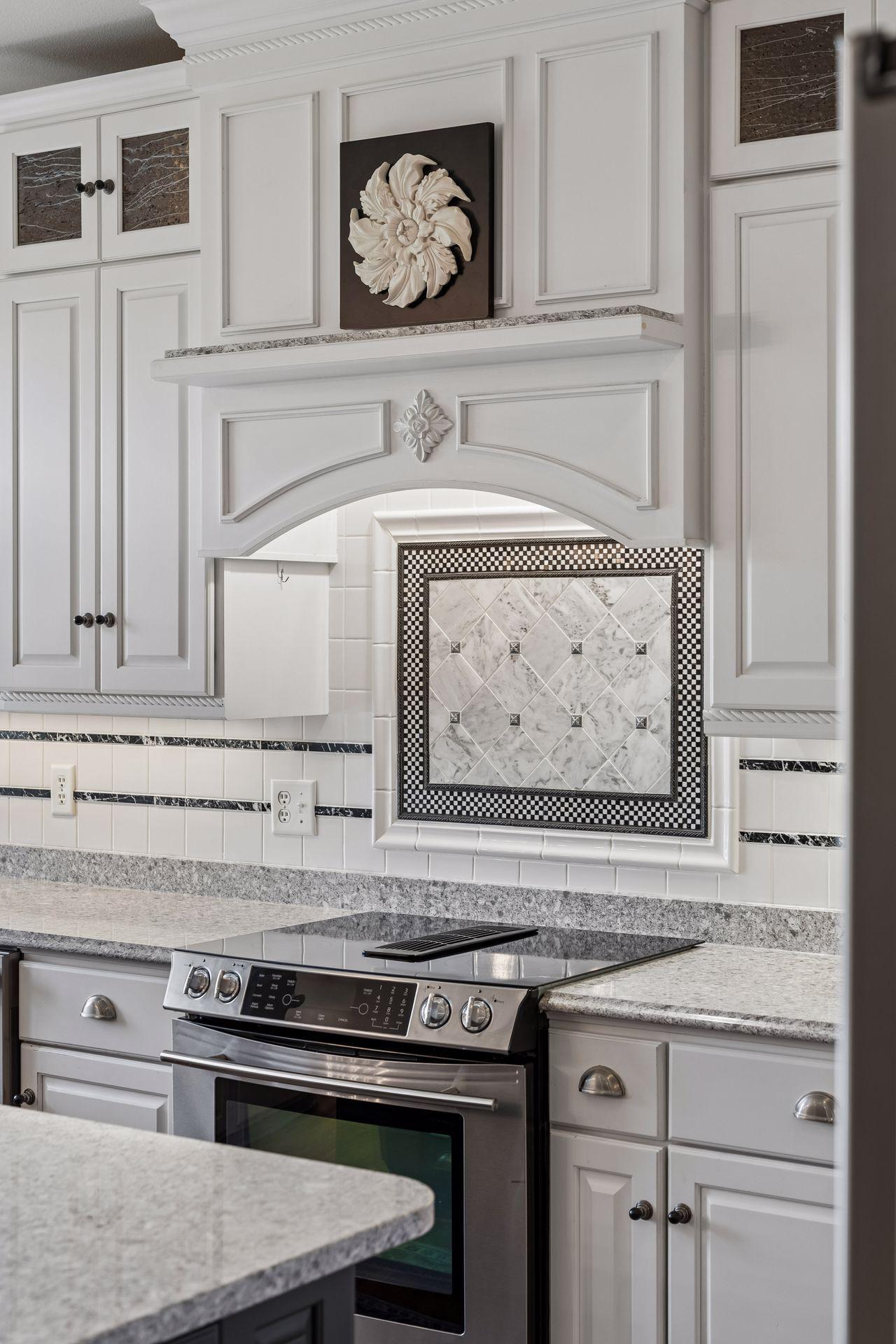 Every detail was thoughtfully selected - from custom cabinetry and decorative tile to the beautifully crafted range hood that serves as the centerpiece of the Kitchen.